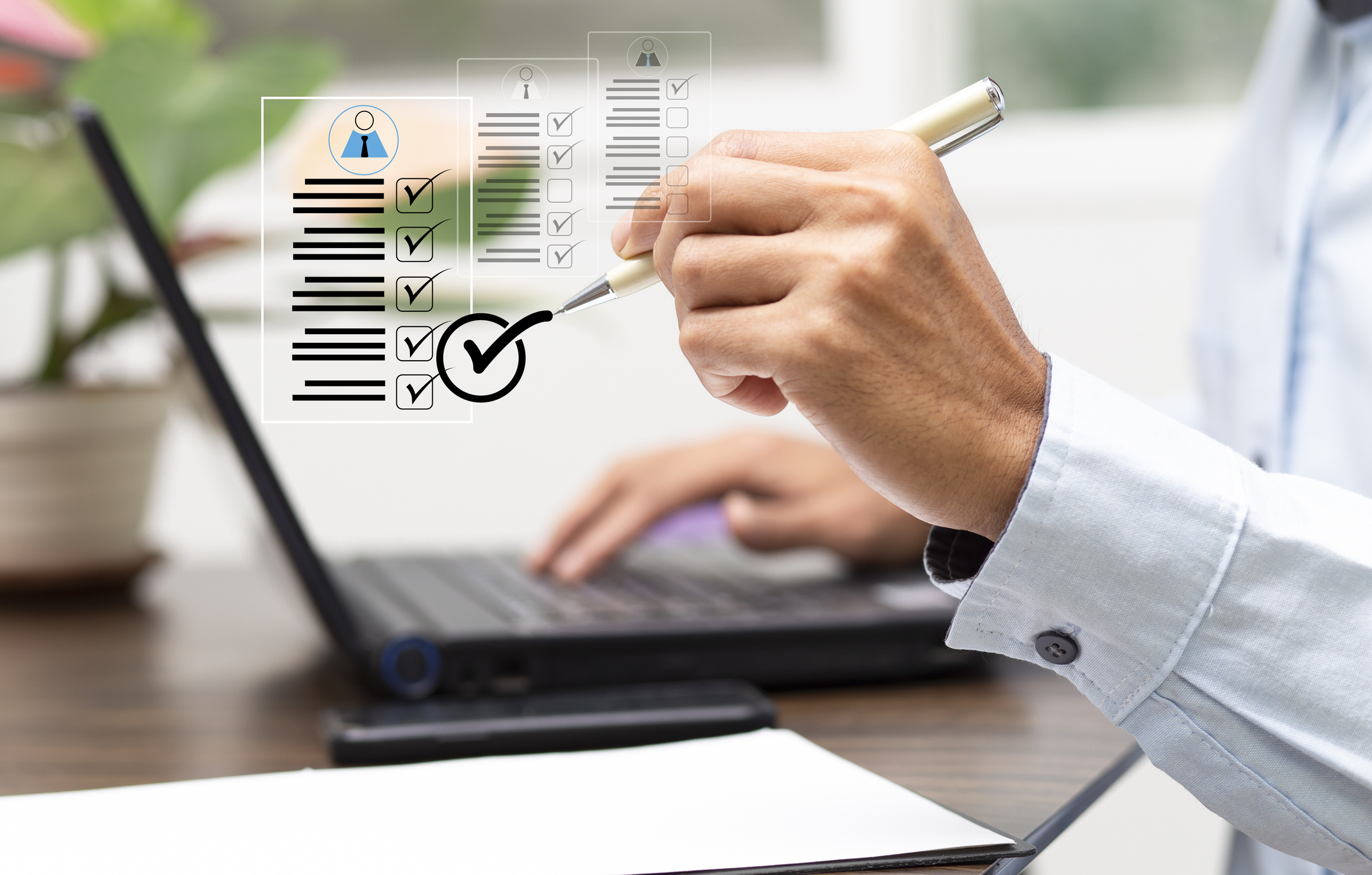 A person sitting at their desk tapping on a completed checklist graphic.